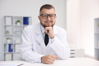 Photo of Portrait of doctor in uniform at table indoors