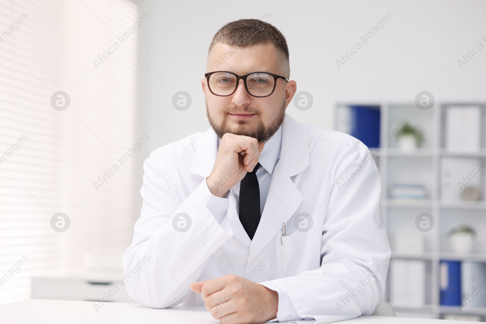 Portrait of doctor in uniform at table indoors Photo of Portrait of doctor in uniform at table indoors