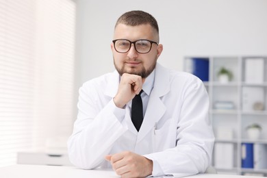 Photo of Portrait of doctor in uniform at table indoors