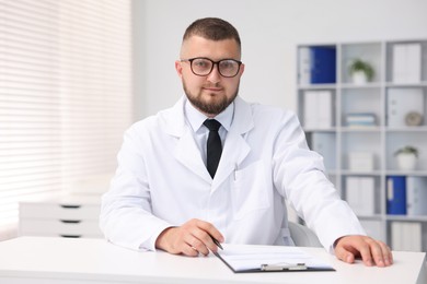 Photo of Portrait of doctor in uniform at table indoors