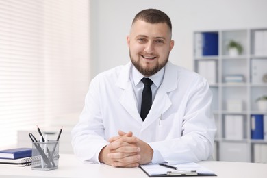 Photo of Portrait of doctor in uniform at table indoors