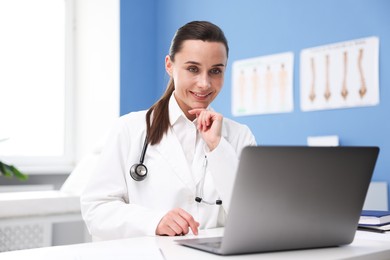 Photo of Doctor having online consultation via laptop in clinic