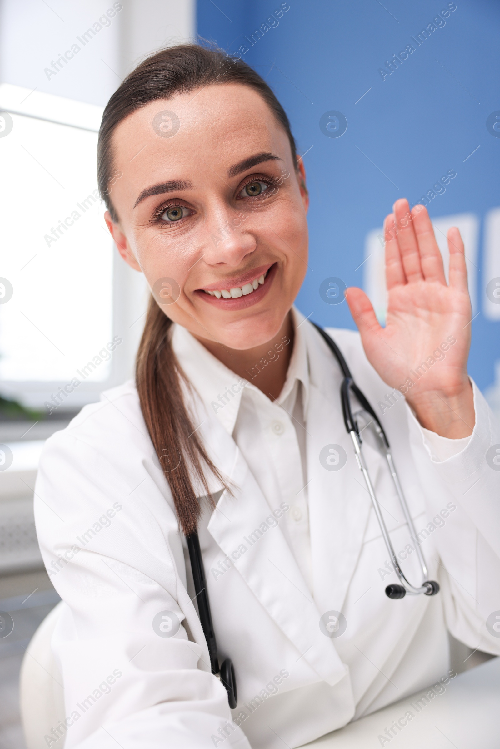 Doctor having online consultation at table in clinic Photo of Doctor having online consultation at table in clinic