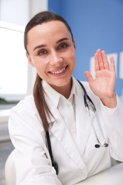 Photo of Doctor having online consultation at table in clinic