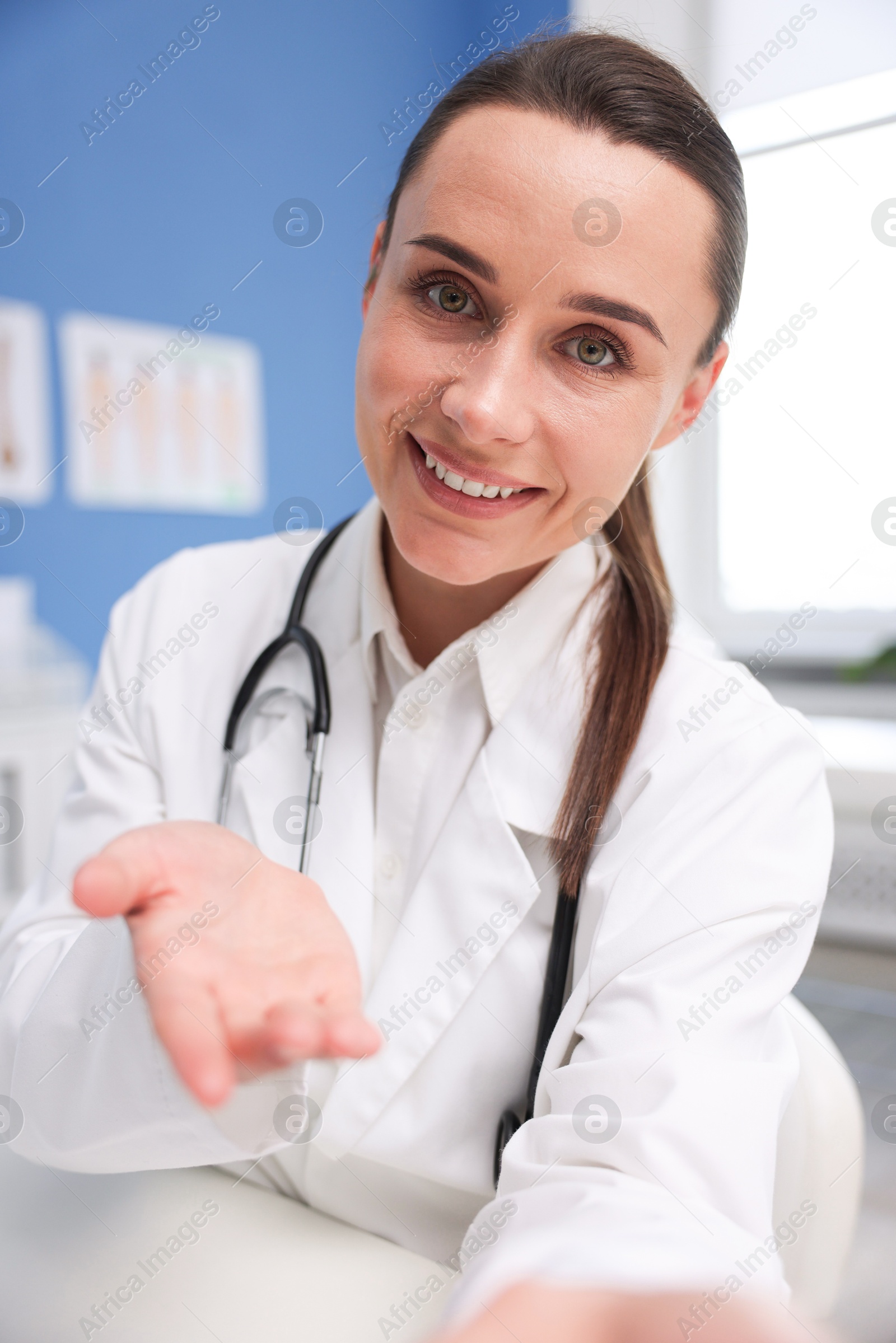 Photo of Doctor having online consultation at table in clinic