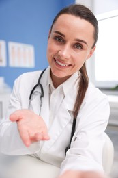 Photo of Doctor having online consultation at table in clinic