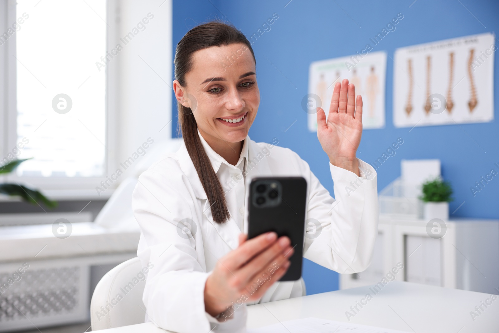 Doctor having online consultation via smartphone in clinic Photo of Doctor having online consultation via smartphone in clinic