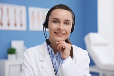Photo of Doctor with headset having online consultation in clinic