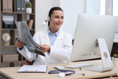 Photo of Doctor with lung MRI scan having online consultation via computer in clinic