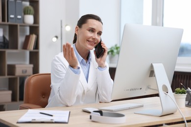 Photo of Doctor with smartphone having online consultation in clinic
