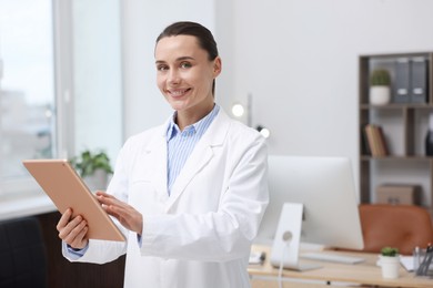 Photo of Doctor using tablet in clinic, space for text. Online medical consultation