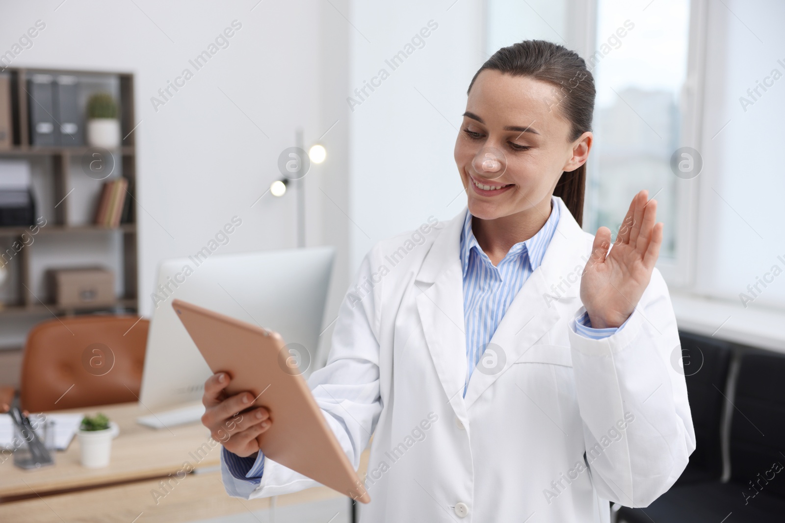 Doctor with tablet having online consultation in clinic Photo of Doctor with tablet having online consultation in clinic