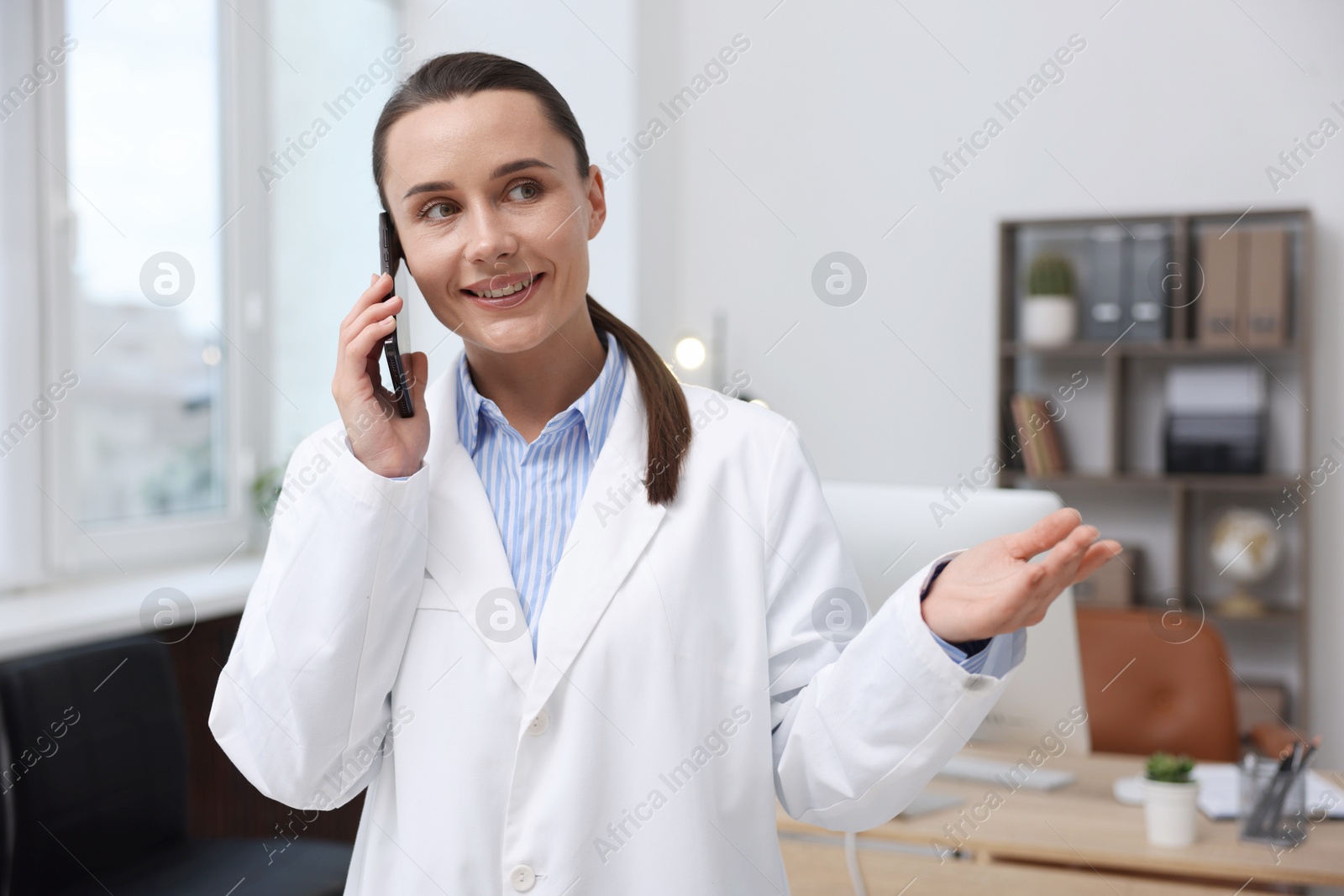 Photo of Doctor with smartphone having online consultation in clinic