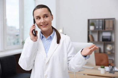 Photo of Doctor with smartphone having online consultation in clinic