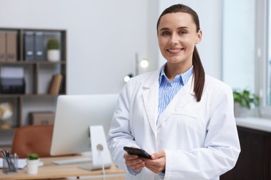 Photo of Doctor with smartphone in clinic, space for text. Online medical consultation