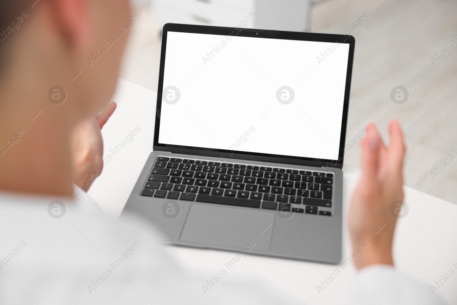 Photo of Doctor having online consultation via laptop in clinic, closeup