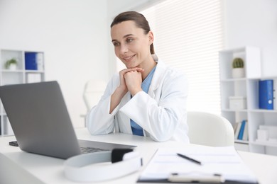 Photo of Doctor having online consultation via laptop in clinic