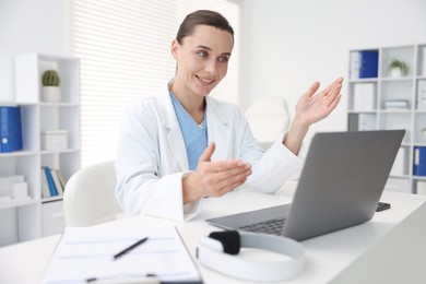 Photo of Doctor having online consultation via laptop in clinic