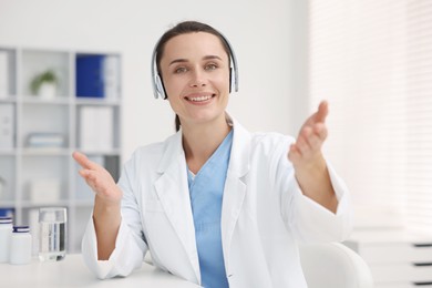 Photo of Doctor in headphones at table indoors. Online medical consultation