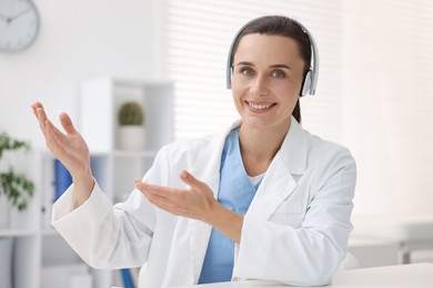 Photo of Doctor in headphones at table indoors. Online medical consultation