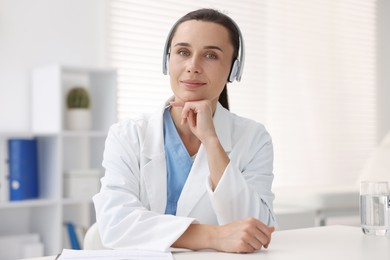 Photo of Doctor in headphones at table indoors. Online medical consultation