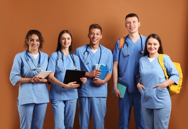 Photo of Group of medical students with books on brown background