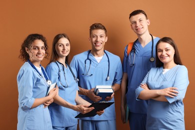 Photo of Group of medical students with books on brown background