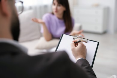 Photo of Professional psychologist working with patient in office, selective focus