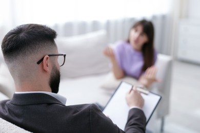 Photo of Professional psychologist working with patient in office, selective focus