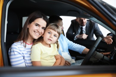 Photo of Salesman showing new car to happy family, selective focus