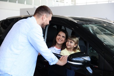Photo of Happy family and new car in salon