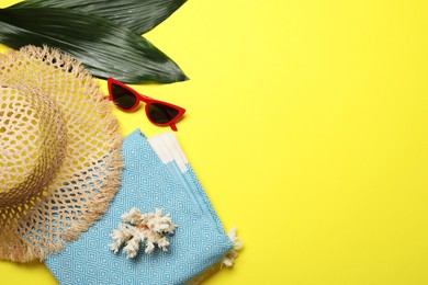 Photo of Flat lay composition with beach towel and other summer accessories on yellow background. Space for text