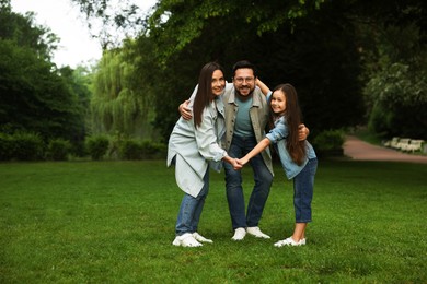 Photo of Happy family posing in park, space for text
