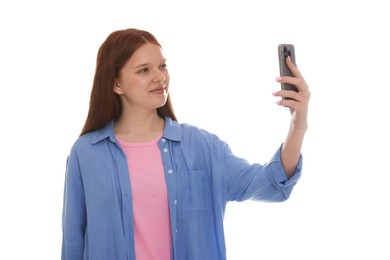 Photo of Beautiful teenage girl taking selfie by smartphone on white background