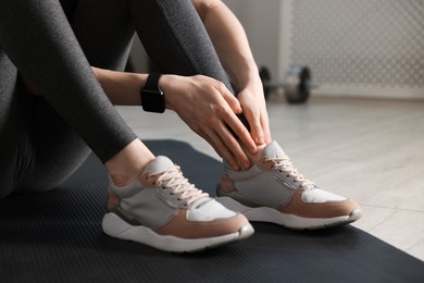Photo of Sports injury. Young woman suffering from leg pain in fitness studio, closeup