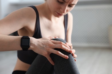 Photo of Sports injury. Young woman suffering from knee pain in fitness studio, selective focus. Space for text
