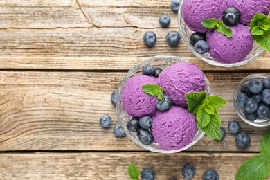 Photo of Tasty sorbet with blueberries and mint in dessert bowls on wooden table, flat lay. Space for text
