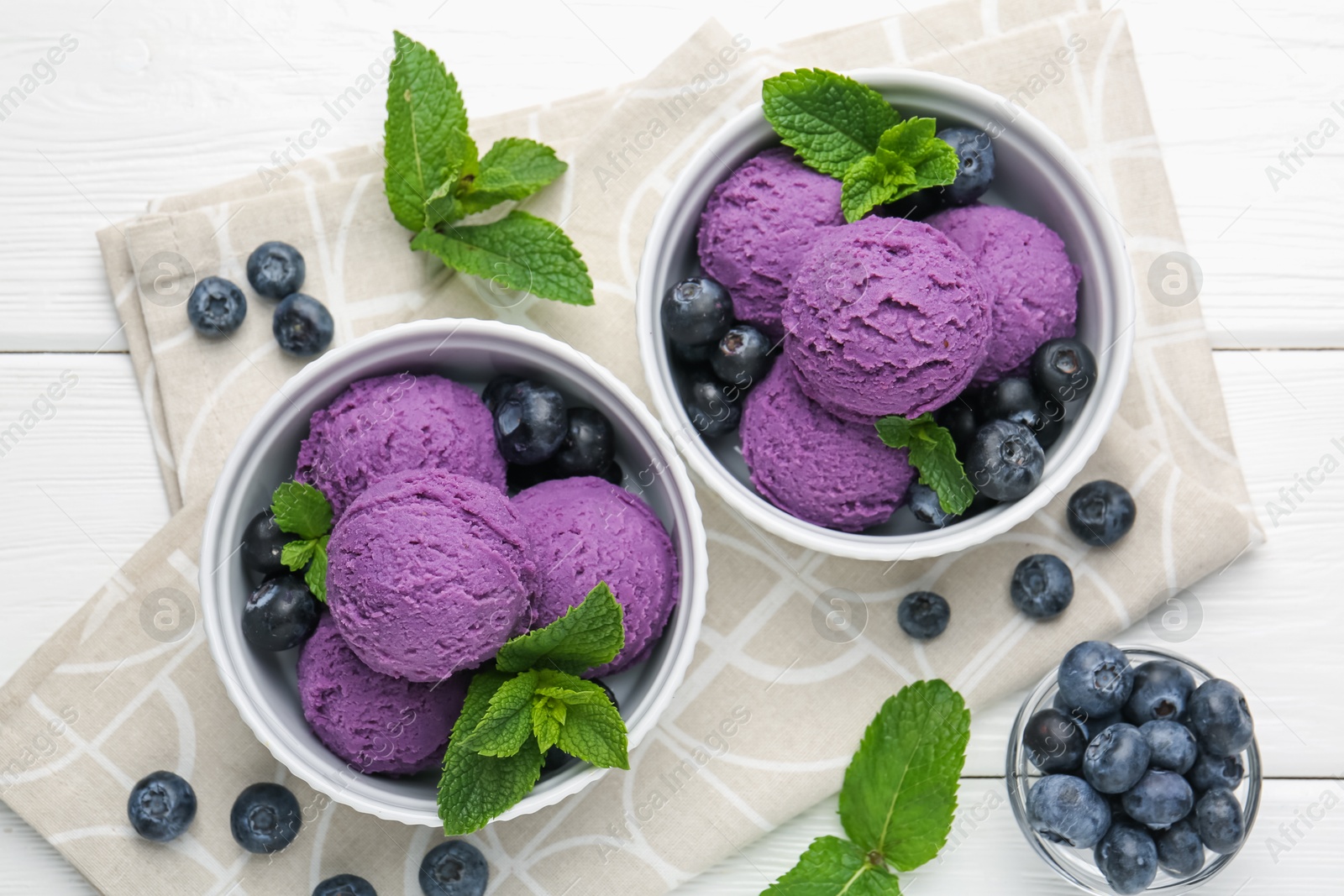 Tasty sorbet with blueberries and mint in bowls on white wooden table, flat lay Photo of Tasty sorbet with blueberries and mint in bowls on white wooden table, flat lay
