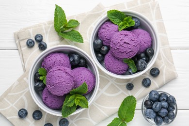 Photo of Tasty sorbet with blueberries and mint in bowls on white wooden table, flat lay