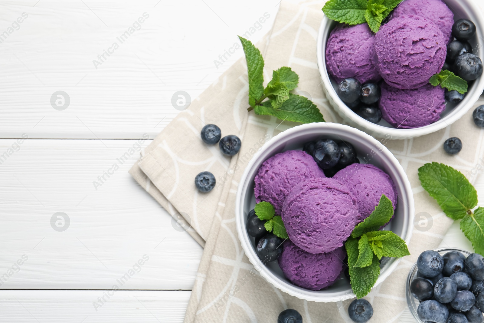 Tasty sorbet with blueberries and mint in bowls on white wooden table, top view. Space for text Photo of Tasty sorbet with blueberries and mint in bowls on white wooden table, top view. Space for text