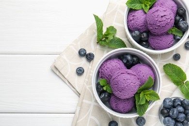 Photo of Tasty sorbet with blueberries and mint in bowls on white wooden table, top view. Space for text