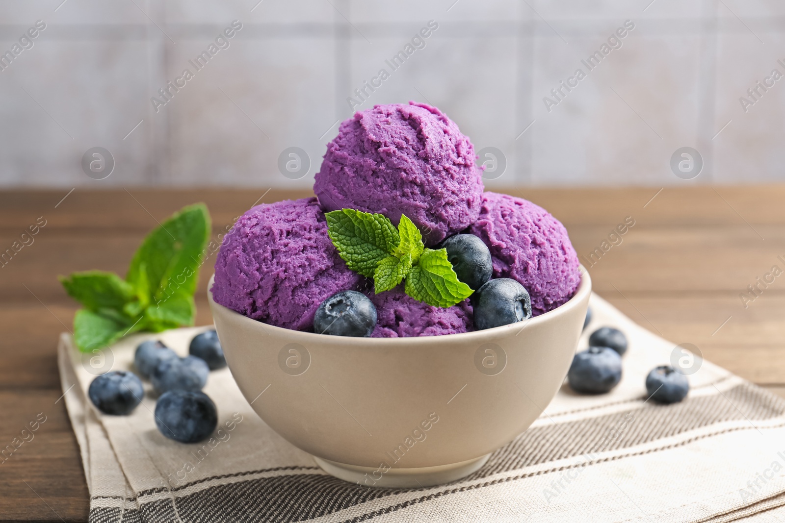 Tasty sorbet with blueberries and mint in bowl on wooden table, closeup Photo of Tasty sorbet with blueberries and mint in bowl on wooden table, closeup
