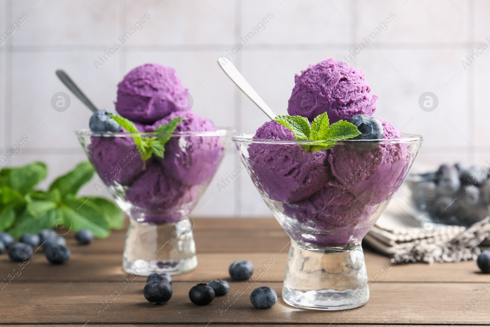 Tasty sorbet with blueberries and mint in dessert bowls on wooden table, closeup Photo of Tasty sorbet with blueberries and mint in dessert bowls on wooden table, closeup
