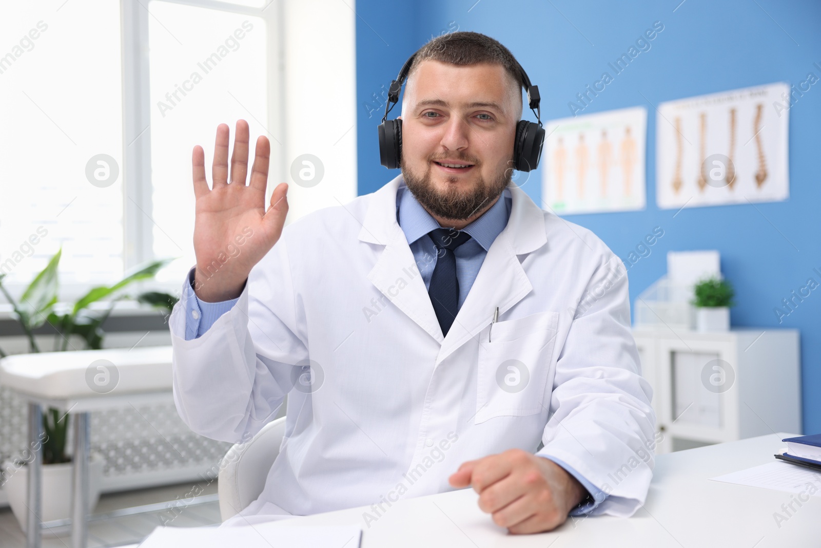 Doctor in headphones having online consultation indoors Photo of Doctor in headphones having online consultation indoors