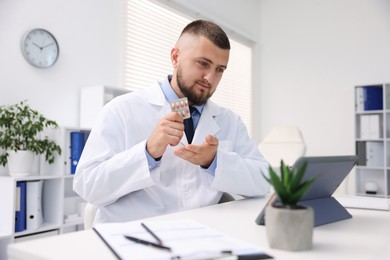 Photo of Doctor with pills having online consultation via tablet indoors