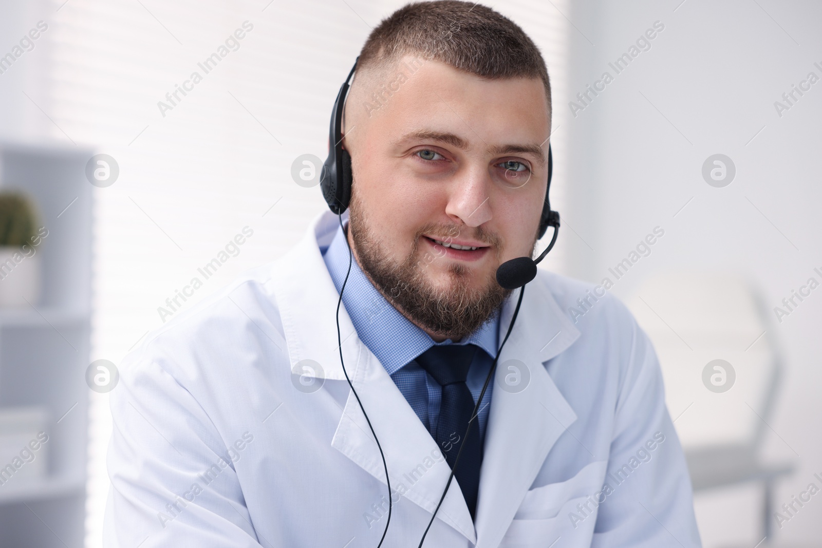 Doctor with headset having online consultation in clinic Photo of Doctor with headset having online consultation in clinic