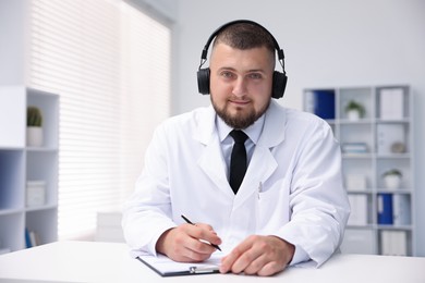 Photo of Doctor in headphones having online consultation indoors
