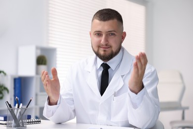 Photo of Portrait of doctor in uniform at table indoors
