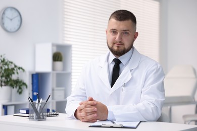 Photo of Portrait of doctor in uniform at table indoors