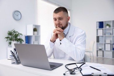 Photo of Doctor having online consultation via laptop in clinic